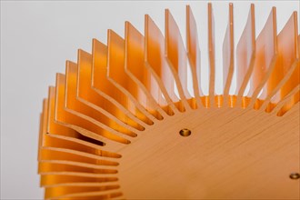 Closeup of fins and mounting surface on round copper computer heat sink on white background