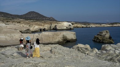 Tourists on the white rock on the coast near Sarakinikoer, Milos, Cyclades, Greece, Europe