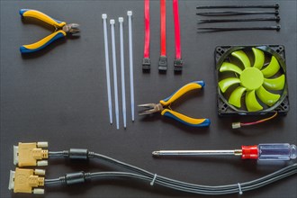 Flat lay of various computer tools and parts on black background