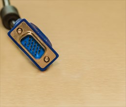 Blue VGA connector of a computer cable against a light background, in South Korea