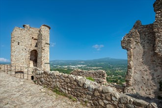 Ruins of Grimaud Castle with a view of the village of Grimaud, in the background the hills of the