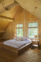 King size bed with wooden frame in master bedroom on upstairs floor inside handcrafted Eastern