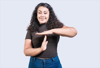 Smiling woman showing time out gesture isolated. Young woman making time out gesture with palms
