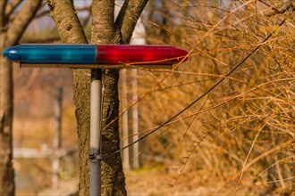 A blue and red emergency light mounted on a pole outdoors, in South Korea