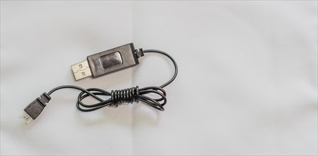 A coiled USB cable with metal accents on a white background, in South Korea