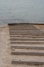 Deserted wooden steps leading down to calm waters on an overcast day, in Ulsan, South Korea, Asia