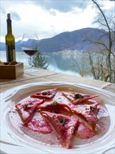 Restaurant Table with Beetroot Ravioli on a White Plate with Mountain View in Switzerland