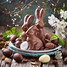 Chocolate Easter bunny with eggs and nuts on a rustic wooden table, Easter symbol, AI generated, AI