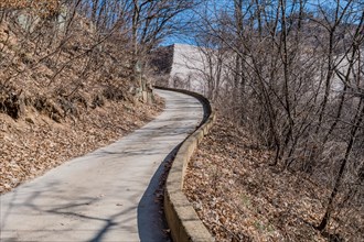 Concrete road leading to mountain fortress wall on winter day in Boeun, South Korea, Asia