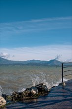 Splashing waves hitting rocks on the shore of Lake Garda, Sirmione, Lake Garda, Italy, Europe