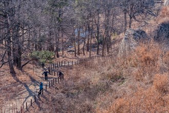 Unidentified tourists walking dirt hiking trail at Samnyeon Mountain Fortress in Boeun, South