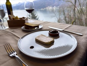 Restaurant Table with Terrine of Foie Gras with Sweet Onion on a White Plate with Mountain View in