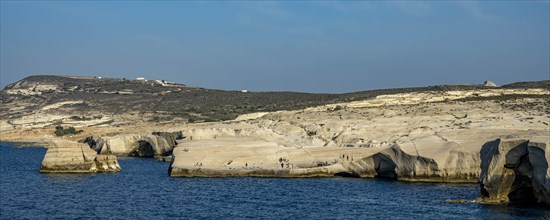 Tourists on the white rocks on the coast near Sarakinikoer, Milos, Cyclades, Greece, Europe