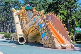 A large dragon-shaped play structure with slides in an outdoor playground, in Ulsan, South Korea,