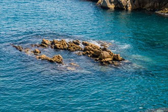 A rocky outcrop in the midst of blue ocean waters on a clear day, in Ulsan, South Korea, Asia