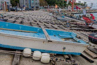 Fishing boats in dry dock with ropes and buoys, awaiting the return to water, in Ulsan, South
