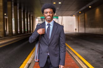 Frontal portrait of an African young architect wearing elegant clothes on road in the city