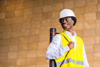 Horizontal photo with copy space and low angle view of a proud african architect wearing helmet and