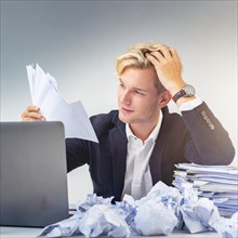 A man in a suit exhausted from work with papers and laptop, symbol bureaucracy, AI generated, AI