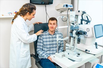 Adult man sitting and talking to specialist in a visit at the ophthalmologist