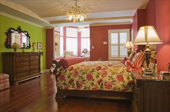 Wooden sleigh bed and night table, dresser in master bedroom on upstairs floor inside elegant style