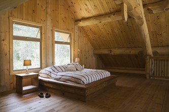 King size bed with wooden frame in master bedroom on upstairs floor inside handcrafted Eastern