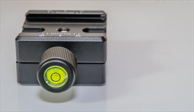 Closeup of bubble level inside locking knob of lock type camera mount for use on tripod