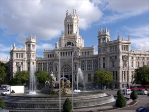 The Cibeles Fountain in front of the Palacio de Cibeles in Madrid on a sunny day with a slightly