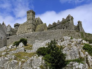 Medieval castle on a rocky outcrop under a cloudy sky Ireland