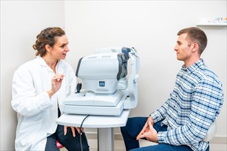Female ophthalmologist explaining the procedure of a scan to a patient in a clinic