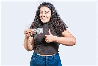 Smiling girl holding a 100 dollar bill gesturing approved. Young woman holding a 100 dollar bill