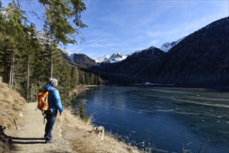 Hikers in winter on an icy lake, Lake Antholz in the Antholz Valley, Val Pusteria, South Tyrol,