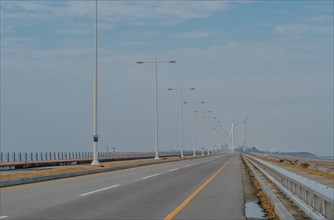 Saemangeum Seawall road with two power generation windmills in distance in Buan, South Korea, Asia