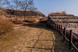 Hiking trail along side section of mountain fortress wall made of flat stones located in Boeun,