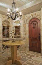 Medieval style beige and tan cut stone wine cellar in basement inside elegant style home, Quebec,