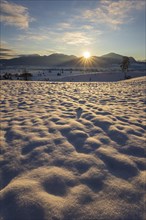 Sunrise over mountains in winter, snow, backlight, sunbeams, Alpine foothills, view of