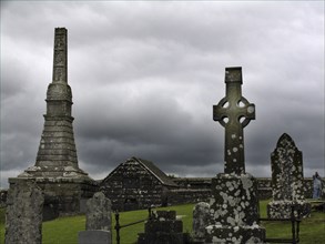 View of a historic cemetery with gravestones and crosses under a cloudy sky Ireland