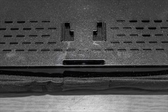 Closeup of holes of mounting plate and speaker in back of car navigation system
