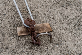 Close-up of rusty nautical hardware anchoring ropes to the ground, in Ulsan, South Korea, Asia