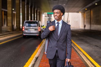 Young african architect commuting to the office walking along an urban path