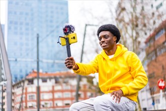 Horizontal three quarter length photo with copy space of a young african streamer using phone to