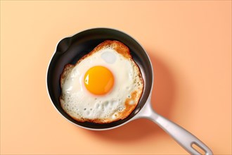 Top vie wof pan with fried egg on beige background. KI generiert, generiert, AI generated