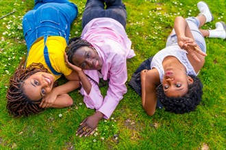 Relaxed african women lying on a park enjoying spring together