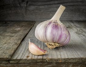 Food, spice, garlic, a whole garlic bulb next to a single clove on a rustic wooden surface, AI