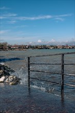 Splashing waves hitting rocks on the shore of Lake Garda, Sirmione, Lake Garda, Italy, Europe