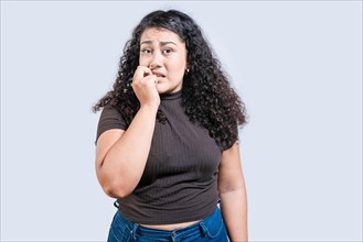 Worried girl biting her nails isolated. Insecure girl biting her nails, looking at camera isolated