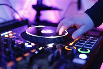 Hand of a DJ on a mixing desk, also called DJ controller or DJ console, at a party, Cologne, North