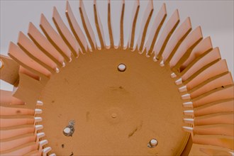 Closeup of copper heat sink fins and fan mounting surface with chipped screw holes