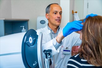 Ophthalmologist and mature woman during treatment for glaucoma using laser machine in a clinic