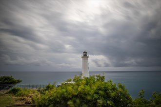 Le Phare du Vieux-Fort, white lighthouse on a cliff. Dramatic clouds with a view of the sea. Pure